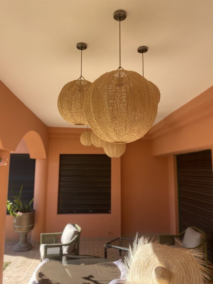 Handmade Moroccan raffia globe pendant light with elongated oval woven shape