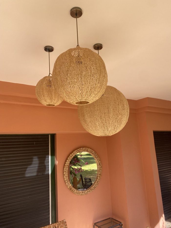 Handmade Moroccan raffia globe pendant light with elongated oval woven shape