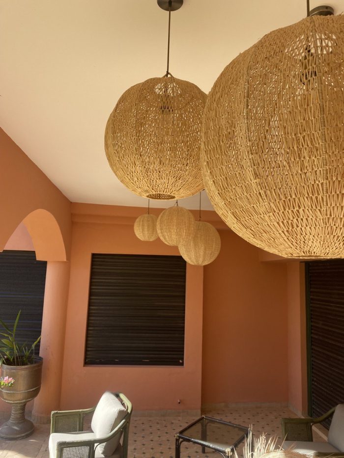 Handmade Moroccan raffia globe pendant light with elongated oval woven shape