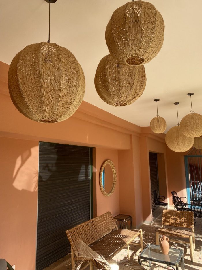 Handmade Moroccan raffia globe pendant light with elongated oval woven shape
