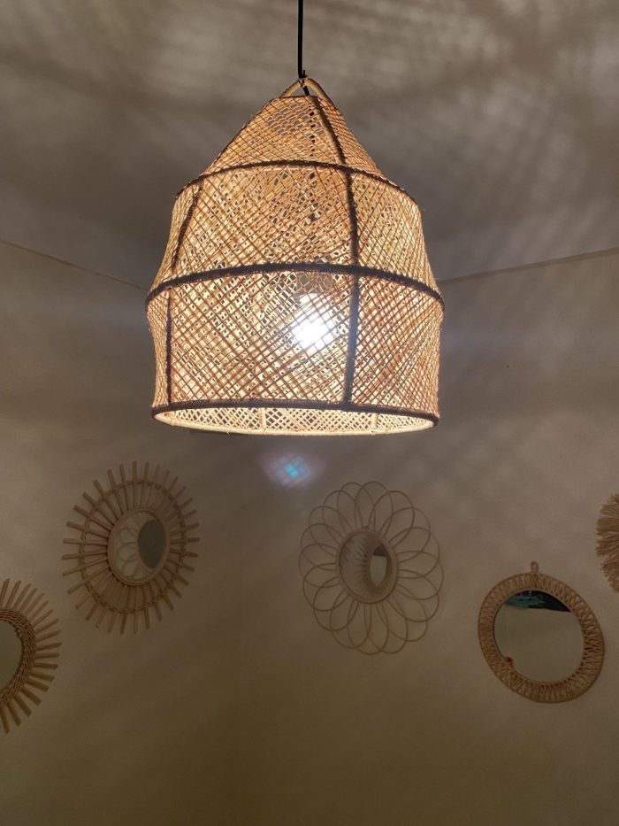 Handwoven raffia lantern pendant with tall tapered shape, natural woven raffia and structured metal frame.