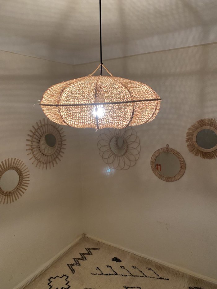 Sculptural Raffia Pendant Light handmade from natural woven raffia with a structured metal frame.