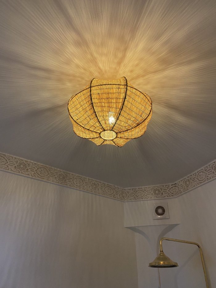 Sculptural petal raffia ceiling light with handwoven natural fibers, metal frame and organic flower-shaped flush mount design.