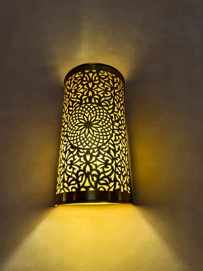 Handmade Moroccan brass wall sconce crafted from solid brass with intricate pierced detailing and warm up-and-down decorative illumination.