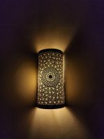 Handmade sunburst brass wall sconce with circular pierced medallion and warm up and down ambient lighting.