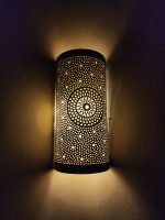 Handmade sunburst brass wall sconce with circular pierced medallion and warm up and down ambient lighting.