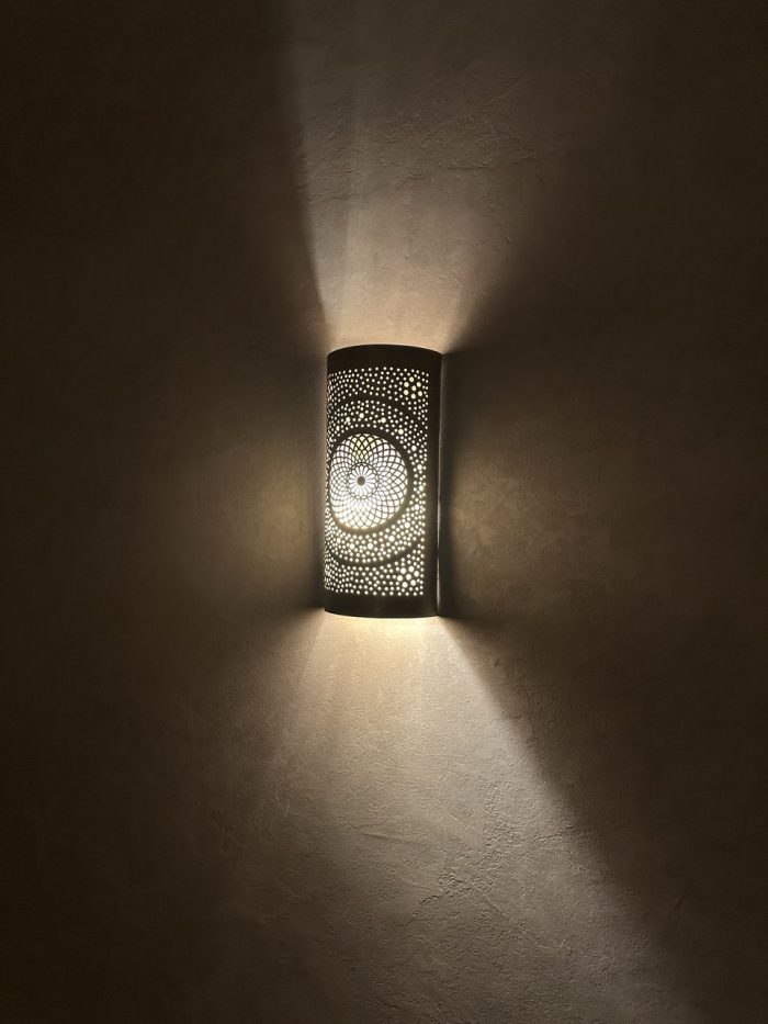 Handmade radiant rosette brass wall sconce with central geometric floral medallion and pierced decorative pattern.