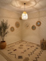 Handwoven raffia lantern pendant with tall tapered shape, natural woven raffia and structured metal frame.