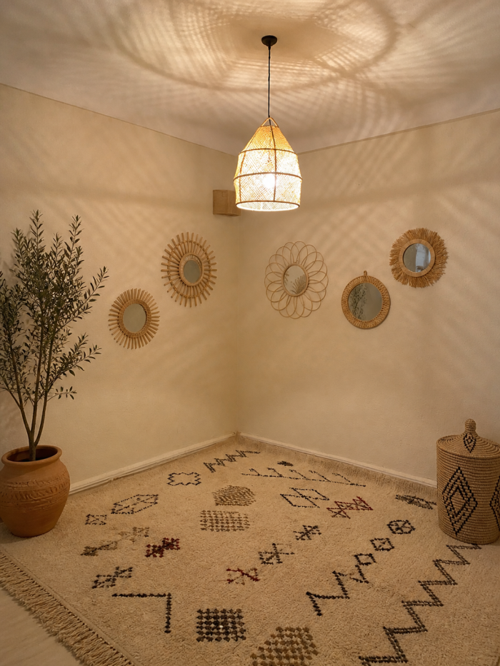 Handwoven raffia lantern pendant with tall tapered shape, natural woven raffia and structured metal frame.