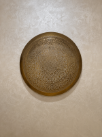 Handmade Moroccan brass wall light with round pierced floral design and warm halo illumination.