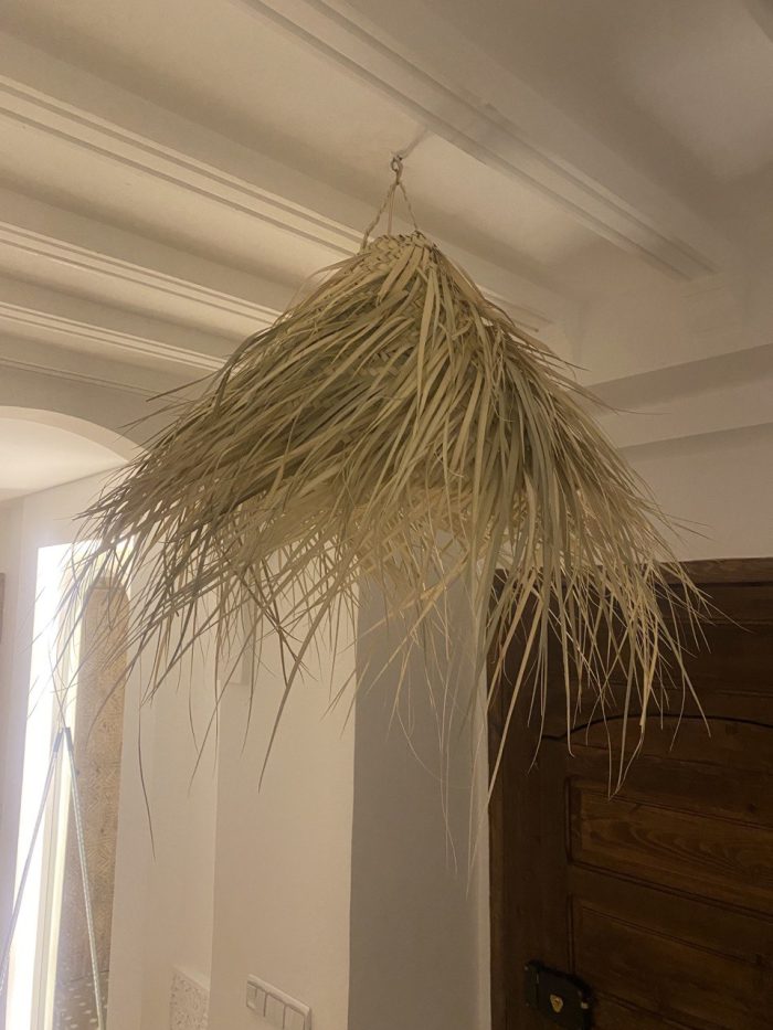 Natural Doum Straw Fringe Pendant Light handmade from woven straw and doum fibers with long flowing fringe.
