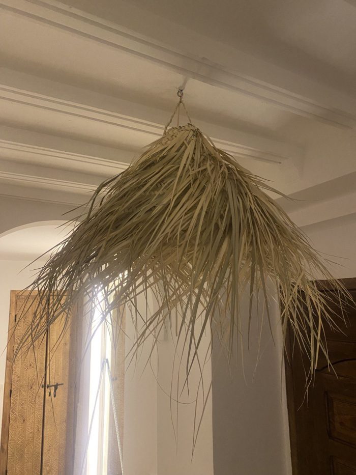 Natural Doum Straw Fringe Pendant Light handmade from woven straw and doum fibers with long flowing fringe.