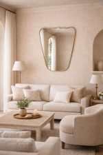 Handmade wavy top brass wall mirror with tapered sides and solid brass frame displayed above bedroom console.