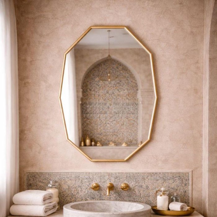Handmade octagonal brass wall mirror with elongated geometric shape and solid brass frame above bathroom vanity.