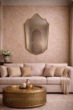 Handmade Moroccan pointed arch brass mirror with slim gold frame above a bathroom vanity.