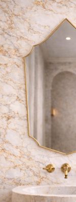 Handmade Moroccan pointed arch brass mirror with slim gold frame above a bathroom vanity.