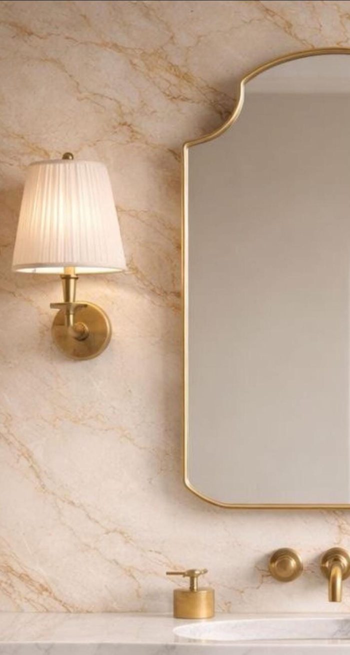Crown Top Brass Mirror above wood bathroom vanity with brass fixtures