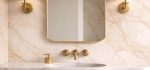 Crown Top Brass Mirror above wood bathroom vanity with brass fixtures
