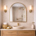 Handmade arched brass wall mirror with slim gold brass frame displayed above a Moroccan bathroom vanity.