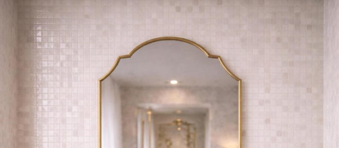Handmade Double Crest Brass Mirror above stone vessel sink and wooden vanity