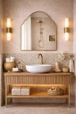 Handmade crown arch brass wall mirror with curved shoulders and slim gold brass frame above a bathroom vanity.
