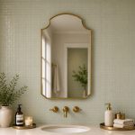 Crown Top Brass Mirror above wood bathroom vanity with brass fixtures
