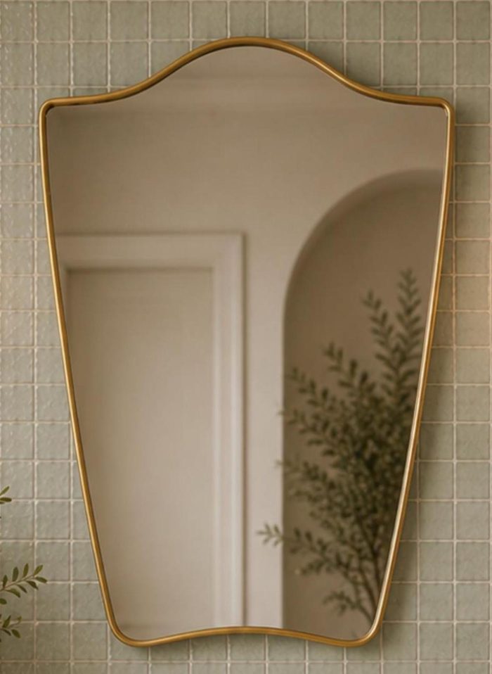 Flared Brass Wall Mirror with handmade sculpted brass frame above bathroom vanity