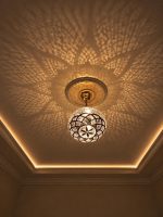 Globe Moroccan Brass Pendant Light casting decorative patterned shadows across ceiling