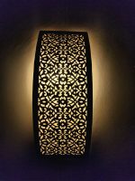 Handmade lattice filigree brass wall sconce with bowed rectangular shape, ornamental openwork and warm ambient lighting.