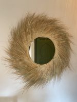 Handwoven palm leaf mirror with round glass center and natural sunburst fringe wall decor