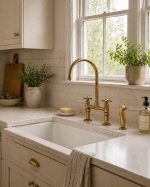 Antique brass bridge faucet with high arc gooseneck spout, cross handles and side sprayer